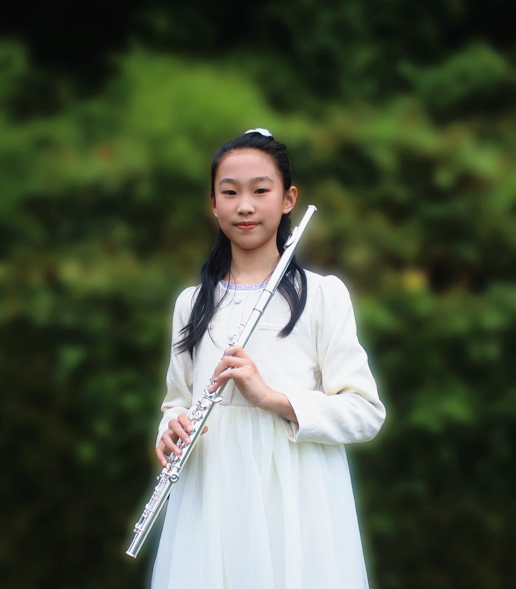 Shanni Li holding her flute outdoors