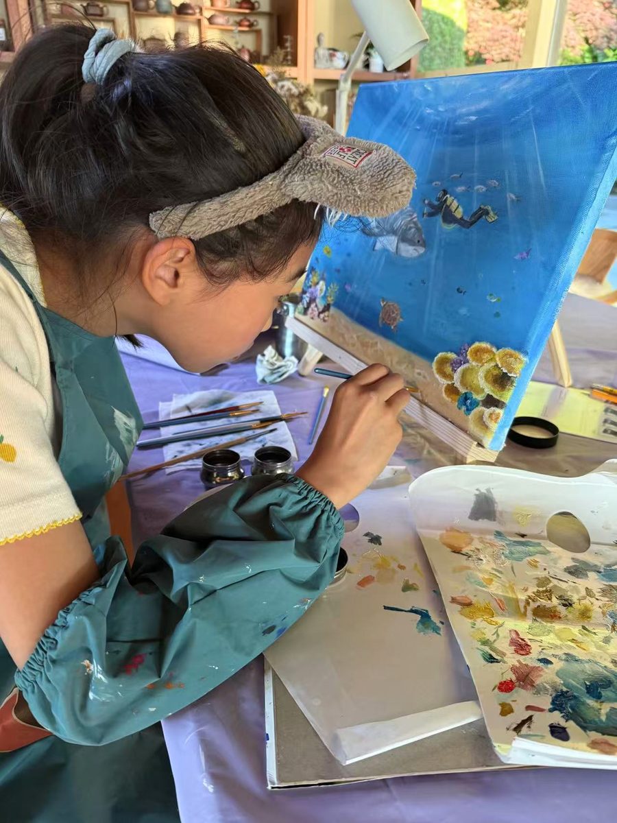 Shanni adding coral reef details to the painting